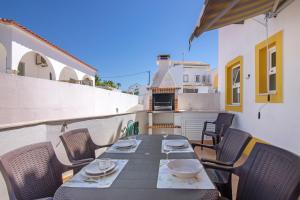 a table and chairs on the balcony of a building at Villa Constança in Manta Rota