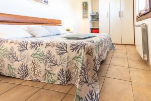 a bedroom with a bed with a comforter on it at Appartamenti Le Querce App. Melograno in Capoliveri