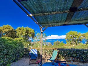 two chairs and a table under a patio umbrella at Appartamenti Le Querce App. Melograno in Capoliveri