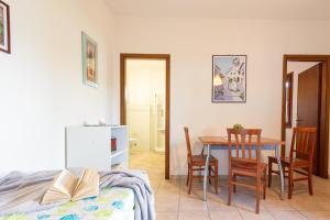 a room with a table and chairs and a bedroom at Appartamenti Le Querce App. Melograno in Capoliveri +11 photos