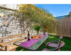 a table with a plate of fruit and a bottle of wine at Ria Sweet Home Paxos in Oziás