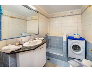 a bathroom with a sink and a washing machine at Ria Sweet Home Paxos in Oziás +18 photos