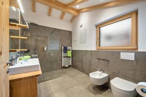 a bathroom with a sink and a toilet and a window at Parliflhof Apt Laugenblick in Meltina +19 photos