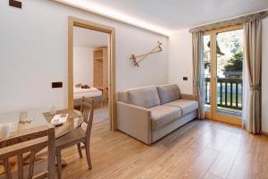 a living room with a couch and a table at Olympic Chalet 11 in Bormio