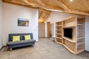 a living room with a couch and a tv and shelves at Parliflhof Apt Laugenblick in Meltina