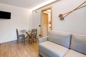 a living room with a couch and a table at Olympic Chalet 11 in Bormio