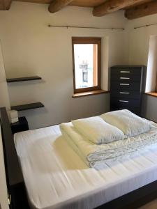 a bedroom with a white bed with a window at Casa D'Ambros - Cadore in Santo Stefano di Cadore