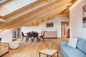 a living room with a blue couch and a table at Alpenloft Meditz in Unterammergau