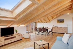a living room with a blue couch and a tv at Alpenloft Meditz in Unterammergau