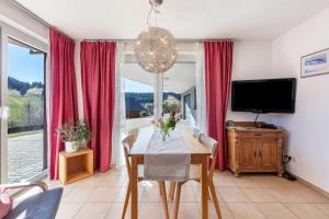a dining room with a table and a tv at Ferienwohnung Bergahorn in Todtnauberg
