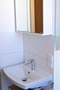 a white sink in a bathroom with a mirror at Ferienwohnung Zum Steiger in Bleicherode +18 photos