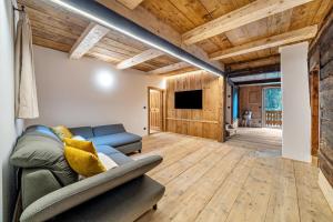 a living room with a couch and a tv at Chalet Lanthalerhof in San Martino