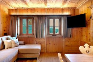 a living room with a couch and a flat screen tv at Daunëihof in Selva di Val Gardena