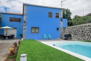 a blue house with a swimming pool in front of it at Casa Las Cañas in Icod de los Vinos