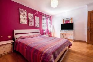 a bedroom with a bed with a purple wall at Casa Las Cañas in Icod de los Vinos