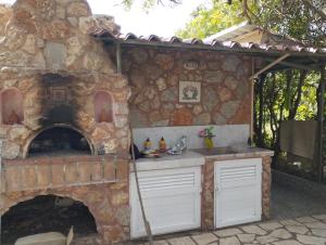 an outdoor kitchen with a stone fireplace at Kos Dream Family Stay in Kos in Zipárion