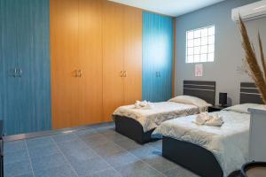 two beds in a room with blue walls at Kos Dream Family Stay in Kos in Zipárion