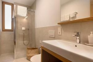 a bathroom with a white sink and a shower at Noreia Pitla in Ortisei