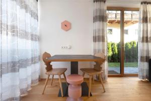 a small table in a room with two stools at Noreia Pitla in Ortisei +21 photos