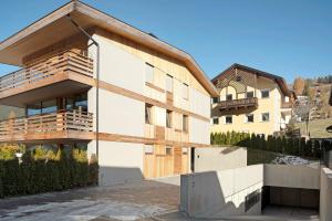 a house with a wooden facade with a balcony at Noreia Pitla in Ortisei