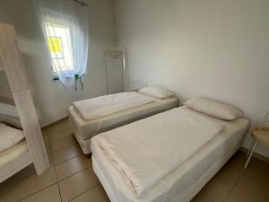 three beds in a room with a window at Dreams Unterkunft in Koetz 