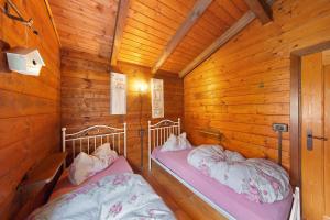 a room with two beds in a wooden cabin at Orserose Chalet 4 Al Vant in Forno di Zoldo +3 photos