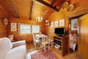 a living room with a table and a television in a cabin at Orserose Chalet 4 Al Vant in Forno di Zoldo