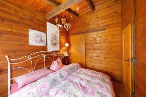 a bedroom with a bed in a wooden cabin at Orserose Chalet 4 Al Vant in Forno di Zoldo