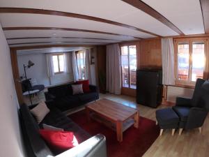 a living room with a couch and a table at Apartment Chalet Nussknacker by Interhome in Lenk