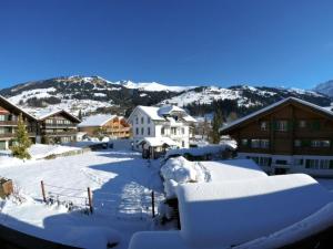 a town covered in snow with houses and mountains at Apartment Chalet Nussknacker by Interhome in Lenk