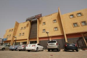 un estacionamiento con autos estacionados frente a un edificio en Raoum Inn Shaqra, en Shaqra