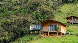 two wooden huts on a hill with trees at Ecoparque Hotel El Cielo Cabañas in Carmen de Viboral +67 photos