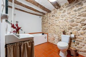 a stone bathroom with a toilet and a sink at Ca la Llum in Tivissa