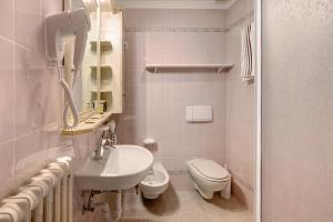 a white bathroom with a toilet and a sink at Appartamenti Elisabetta n2 in Livigno +14 photos