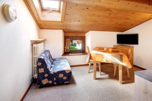a room with a table and a chair and a television at Appartamenti Elisabetta n2 in Livigno
