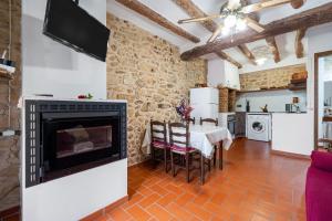 a living room with a fireplace and a table with chairs at Ca la Llum in Tivissa +16 photos