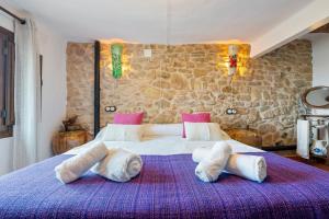 a bedroom with a large bed with four pillows at Ca la Llum in Tivissa