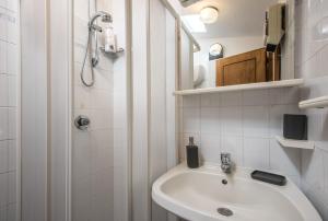 a white bathroom with a sink and a shower at Casa Francesca in Montalcino +17 photos