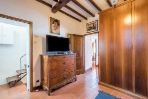a living room with a television on a wooden dresser at Casa Francesca in Montalcino