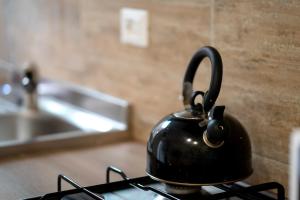 a black tea kettle sitting on top of a stove at Hemingway's Shelter in La Spezia +17 photos