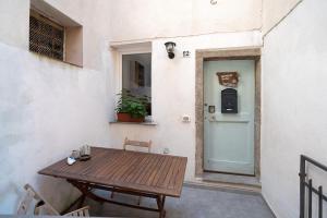 a wooden table sitting on a patio next to a door at Hemingway's Shelter in La Spezia