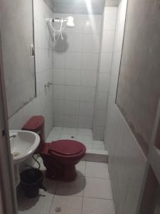 a bathroom with a red toilet and a sink at Casa de huespedes en el centro in Cajamarca