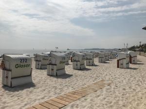 a row of beach chairs on a sandy beach at Ferienwohnung Schmidt Haffkamp in Grömitz +8 photos