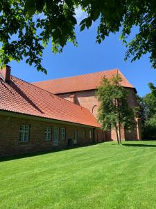 a large brick building with a tree in the yard at Ferienwohnung Schmidt Haffkamp in Grömitz