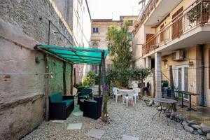 an alley with a green canopy and tables and chairs at Il Borgo Incantato con garage in Finale Ligure