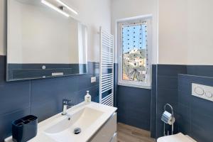 a bathroom with a white sink and a window at Il Borgo Incantato con garage in Finale Ligure +30 photos