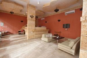 a living room with red walls and couches and a tv at Raoum Inn Shaqra in Shaqra