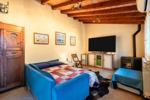 a bedroom with a blue couch and a flat screen tv at Residence Al Pozzo in Capannori +16 photos