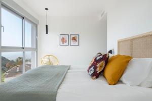a bedroom with a bed with pillows and a window at Central Apartment with a view in Mijas +21 photos