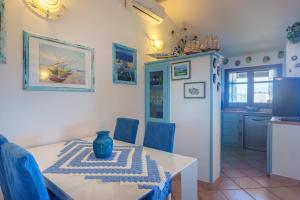 a kitchen and dining room with a table and a refrigerator at La Terrazza sul mare in Palau